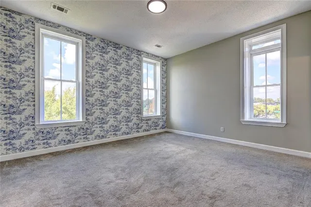 an empty room with windows and closet