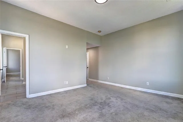 an empty room with closet and mirror