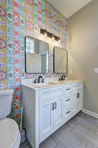 a bathroom with a double vanity sink mirror and toilet
