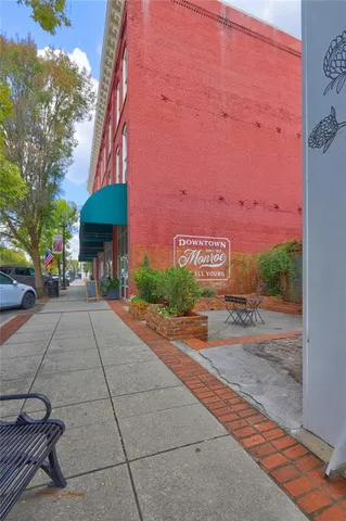 a view of a building with a yard and a car parked in front of it