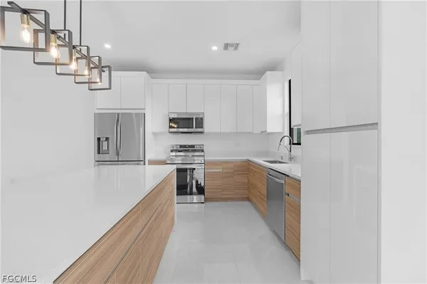 a kitchen with kitchen island white cabinets and stainless steel appliances