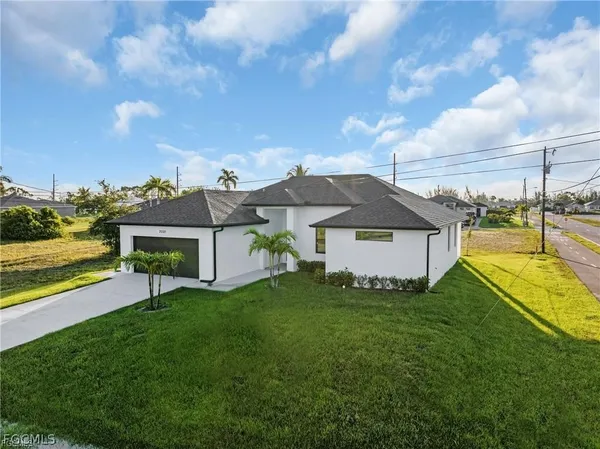 a view of a house with a big yard and a large tree