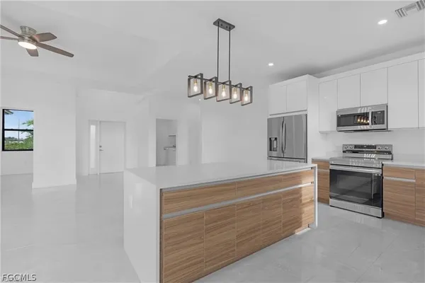 a kitchen with granite countertop a refrigerator and a stove top oven