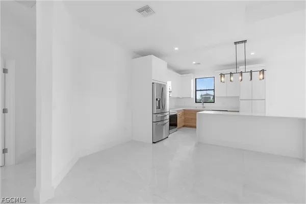 a large white kitchen with cabinets