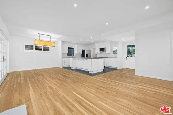 a view of a bedroom with wooden floor and window