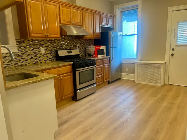 a kitchen with granite countertop a stove and a wooden floors