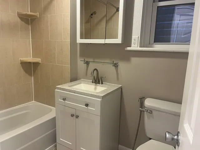 a bathroom with a sink a toilet and shower