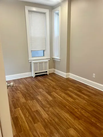 a view of an empty room with wooden floor