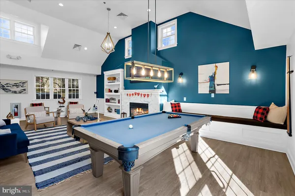 a living room with furniture a flat screen tv and a pool table