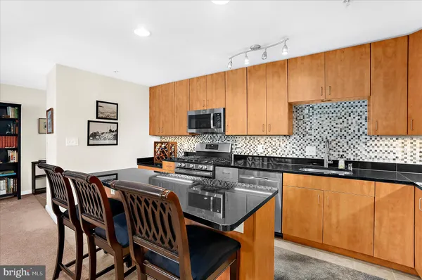 a kitchen with granite countertop wooden cabinets a dining table and chairs