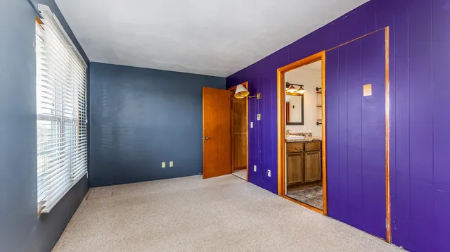 a view of empty room with window and bathroom