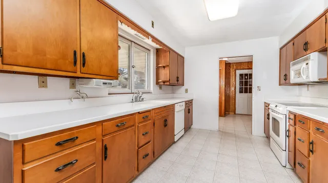 a large kitchen with stainless steel appliances granite countertop a sink and a stove