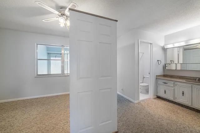 a bathroom with a granite countertop sink a large mirror and a bathtub
