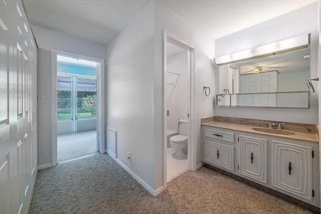 a spacious bathroom with a granite countertop sink mirror and toilet