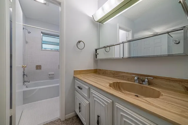 a bathroom with a sink a vanity and shower