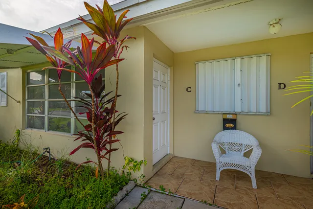 a vase of flowers sitting on a table in front of a door