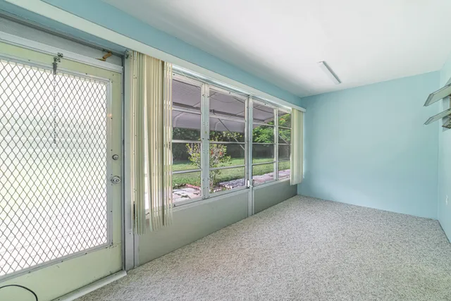 a view of an empty room with wooden floor and windows