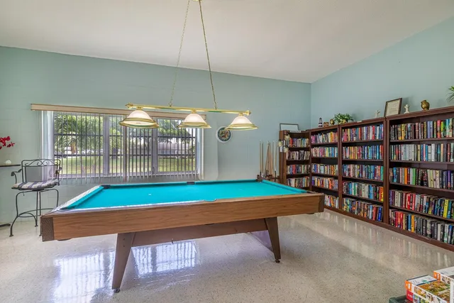 a room with furniture pool table and windows