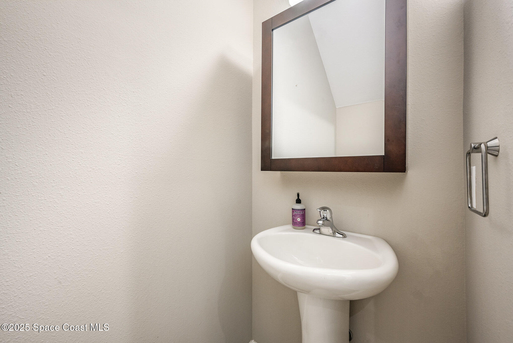 3226 Arden Circle Melbourne, FL 32934 - Photo 17 of 43 a bathroom with a sink a mirror and vanity