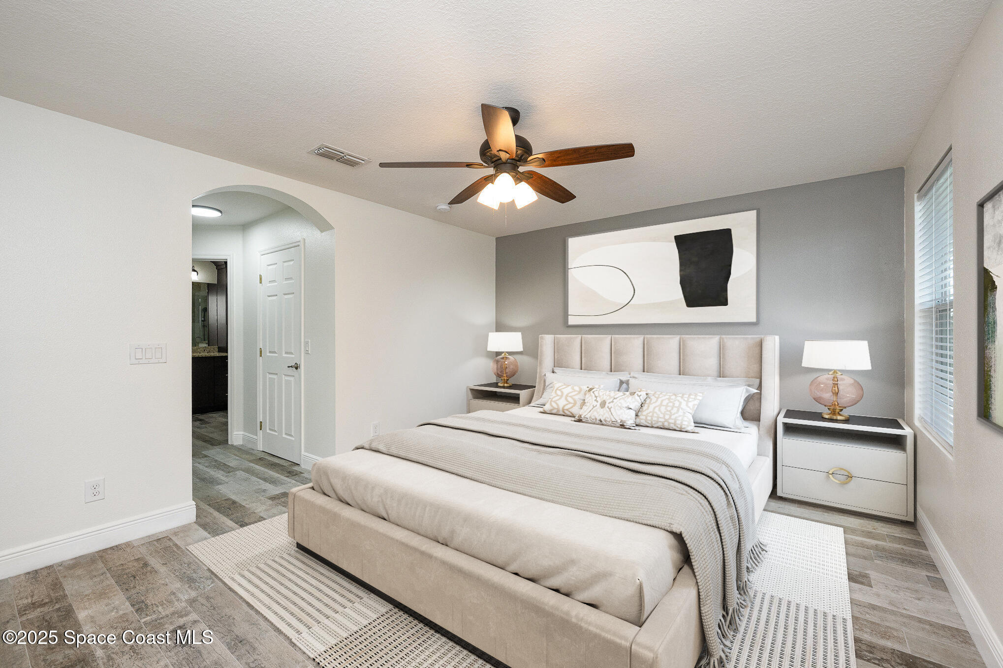 3226 Arden Circle Melbourne, FL 32934 - Photo 22 of 43 a bedroom with a large bed and a chandelier