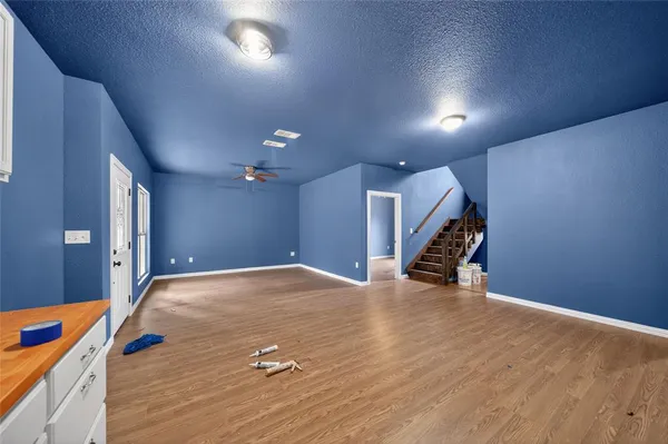 an empty room with wooden floor and stairs