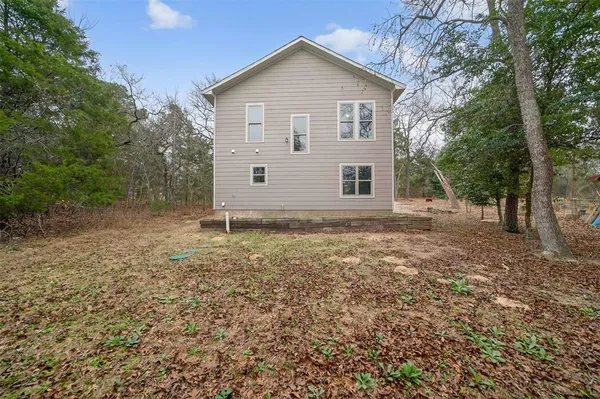 a view of a house with backyard and trees