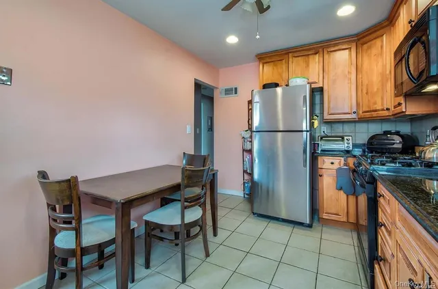 a kitchen with a table chairs refrigerator and cabinets