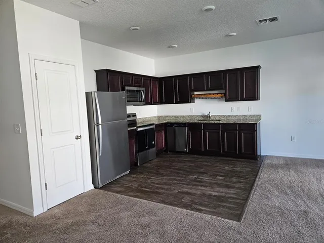 a kitchen with stainless steel appliances a refrigerator and a stove