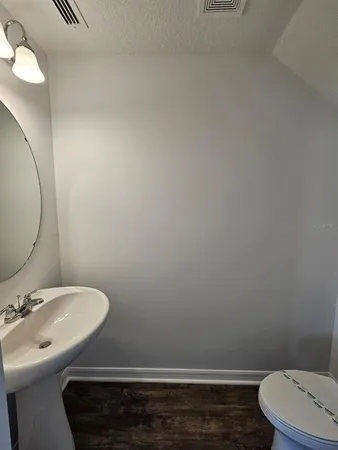 a bathroom with a sink mirror and toilet