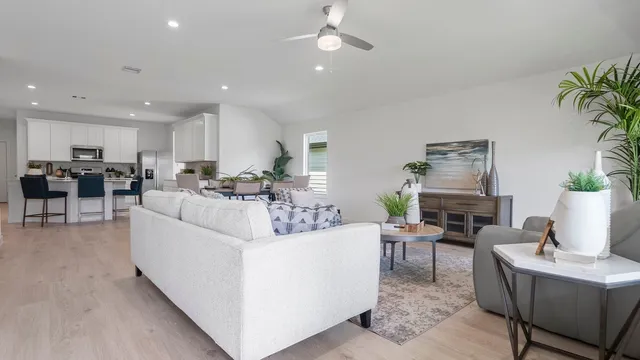 a living room with furniture and a kitchen area