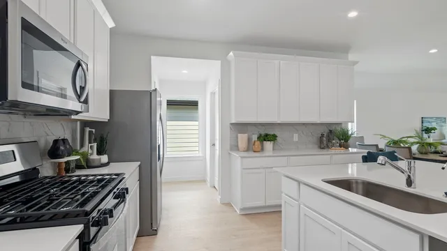 a kitchen with a sink stove top oven and cabinets