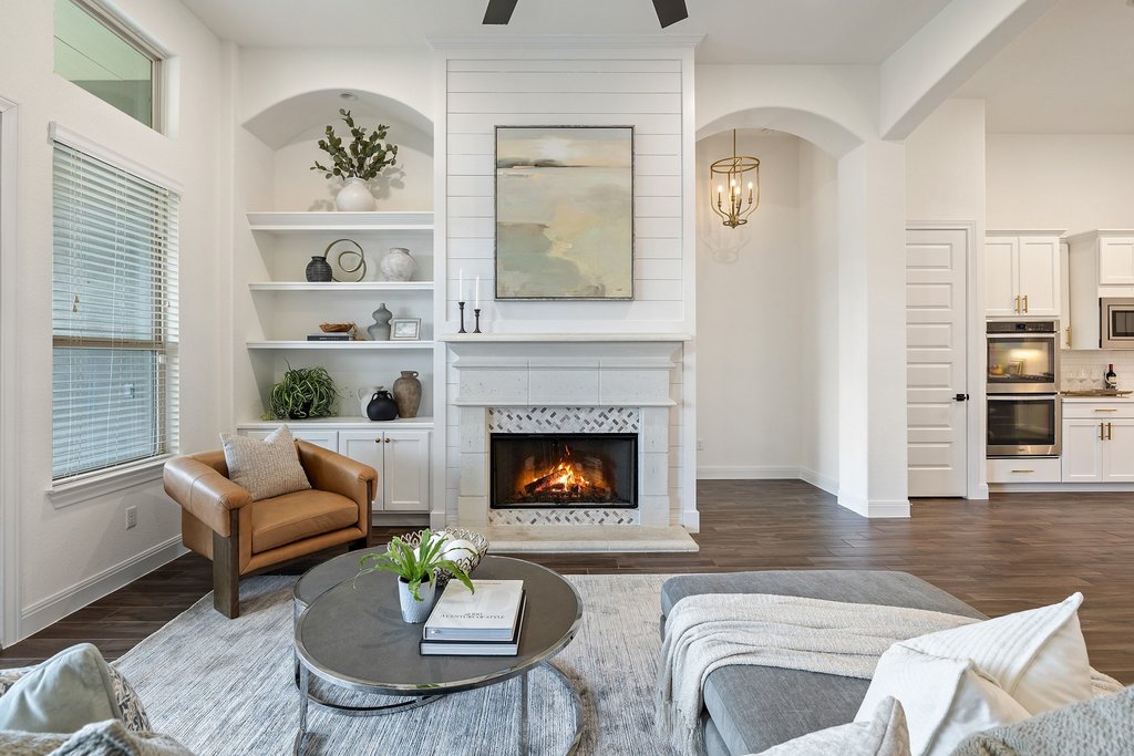 17641 Stratus Cove Dripping Springs, TX 78620 - Photo 17 of 40 Living room featuring built in shelves, a ceiling fan, a fireplace, and dark wood finished floors