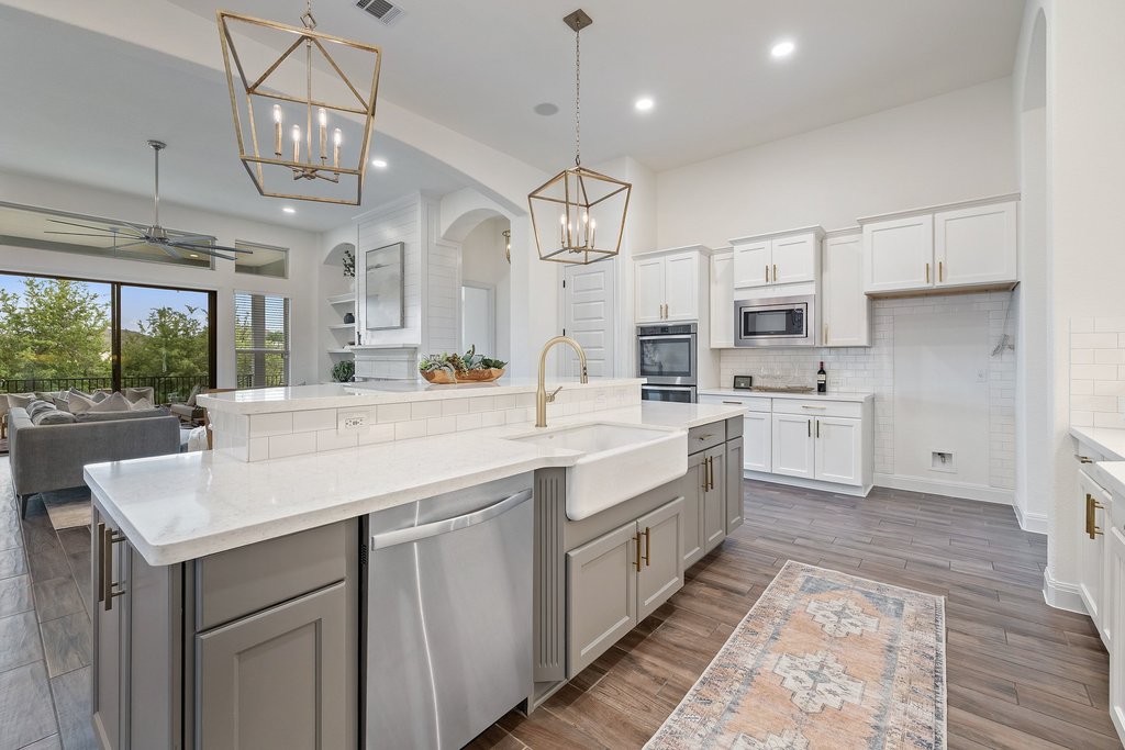 17641 Stratus Cove Dripping Springs, TX 78620 - Photo 38 of 40 Kitchen featuring a ceiling fan, stainless steel appliances, open floor plan, arched walkways, and dual tone cabinetry