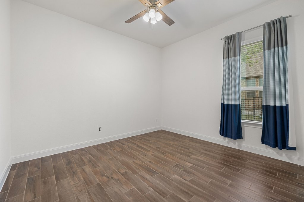 17641 Stratus Cove Dripping Springs, TX 78620 - Photo 26 of 40 Unfurnished room featuring wood finish floors and ceiling fan