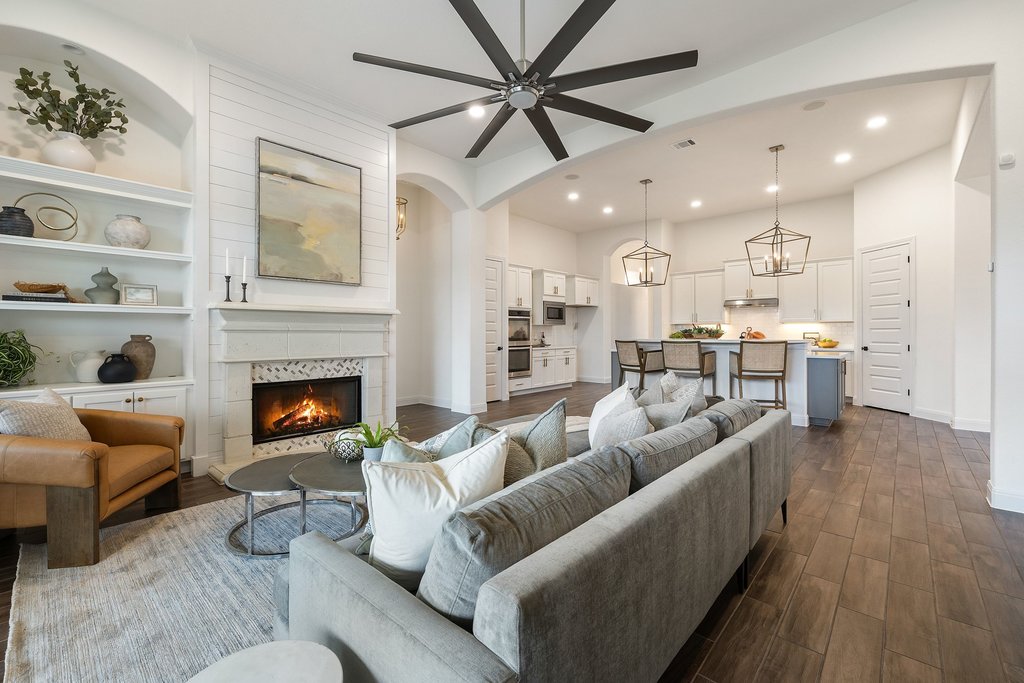 17641 Stratus Cove Dripping Springs, TX 78620 - Photo 2 of 40 Living area with built in shelves, dark wood-style flooring, a fireplace, ceiling fan, and recessed lighting