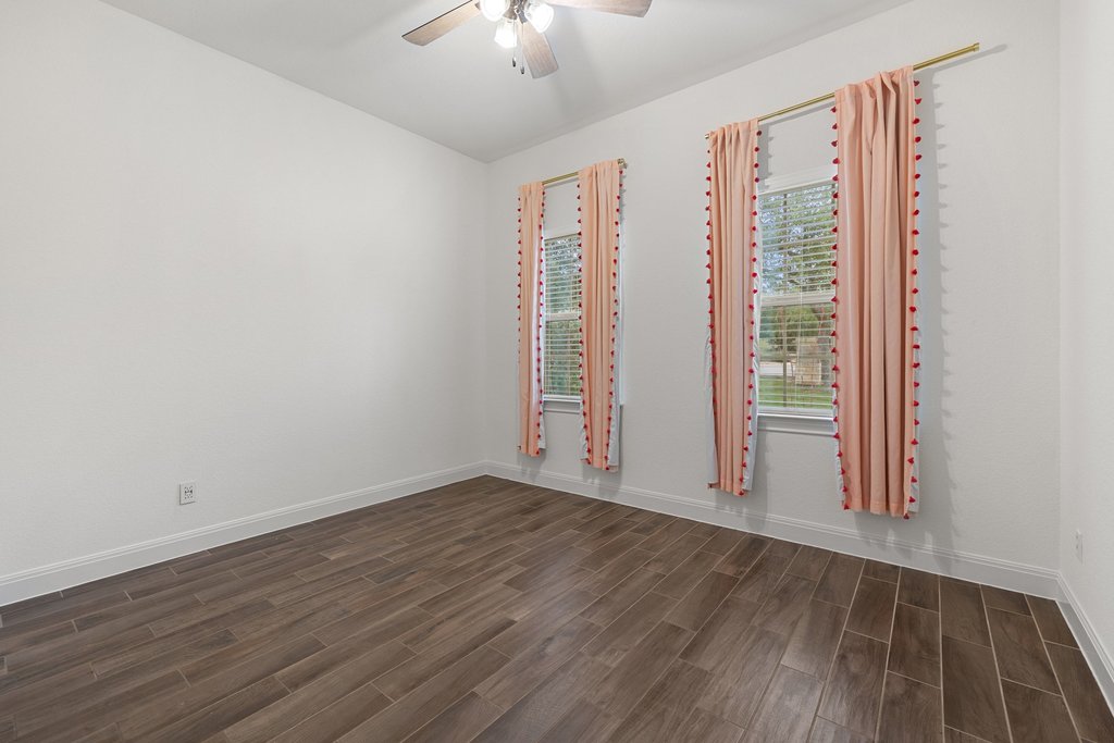 17641 Stratus Cove Dripping Springs, TX 78620 - Photo 28 of 40 Empty room with wood finish floors and a ceiling fan