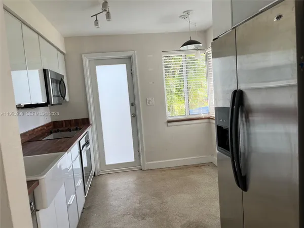 a kitchen with a refrigerator and a stove top oven