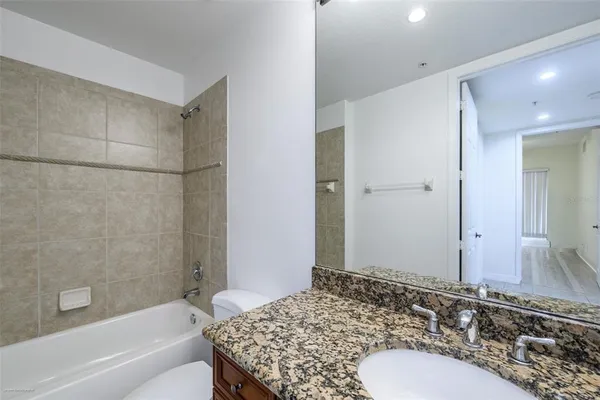 a kitchen with stainless steel appliances granite countertop a sink counter space cabinets and a refrigerator