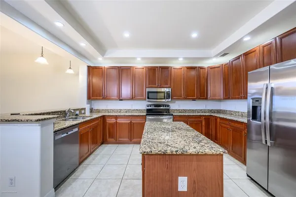 a kitchen with stainless steel appliances granite countertop a stove a refrigerator a sink and dishwasher