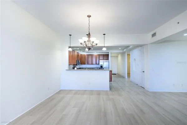 a view of a kitchen with a stove wooden floor and a chandelier