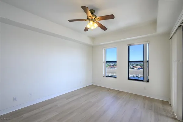 a view of an empty room with a window and wooden floor