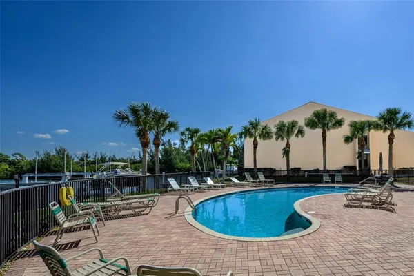 a swimming pool with outdoor seating and yard in the back