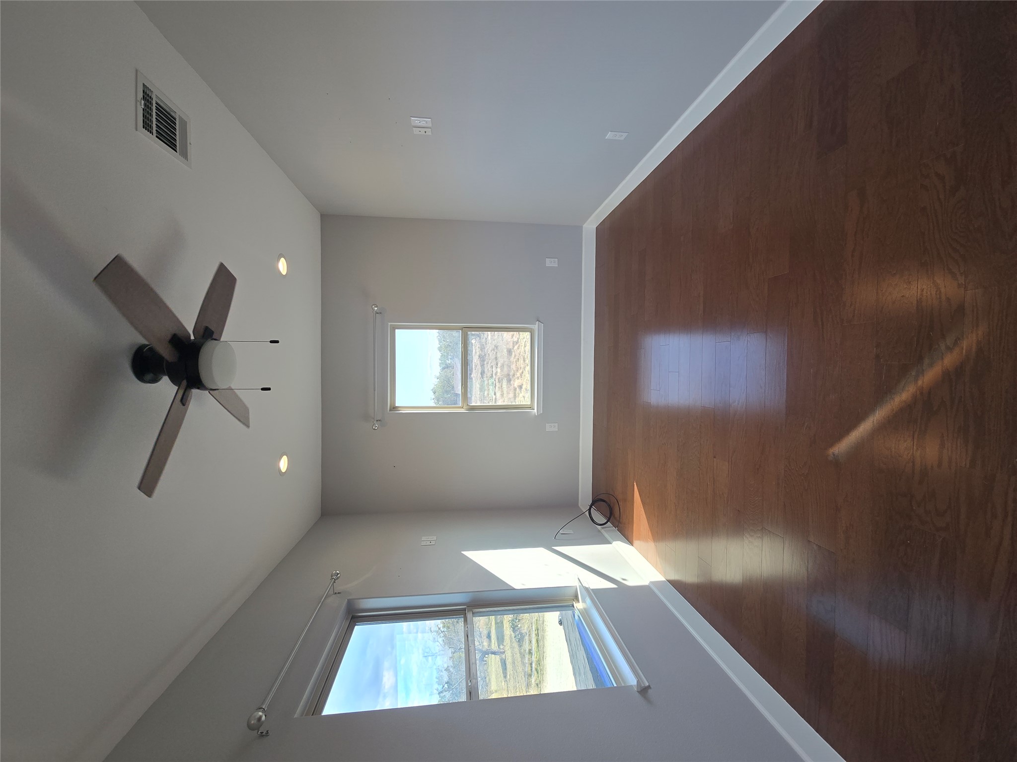304 Spring Street Burnet, TX 78611 - Photo 10 of 11 Spare room with a ceiling fan, dark wood finished floors, plenty of natural light, and recessed lighting