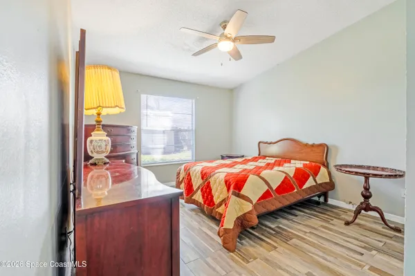 a bedroom with a bed and wooden floor