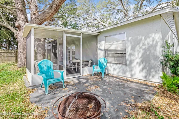 a view of a chair and table in backyard of the house