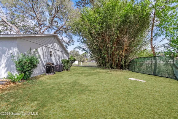 a backyard of a house with lots of green space and fountain