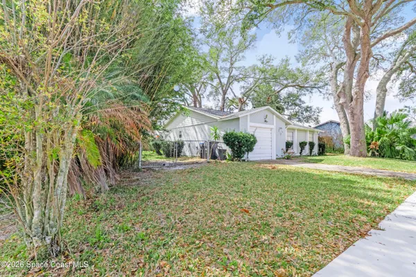 a front view of a house with a yard and trees