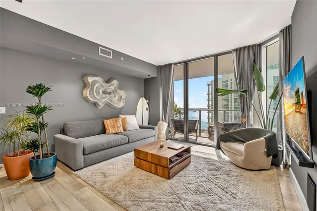 a living room with furniture potted plant and a large window