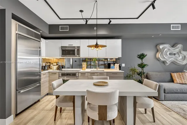 a kitchen with a table chairs and stainless steel appliances