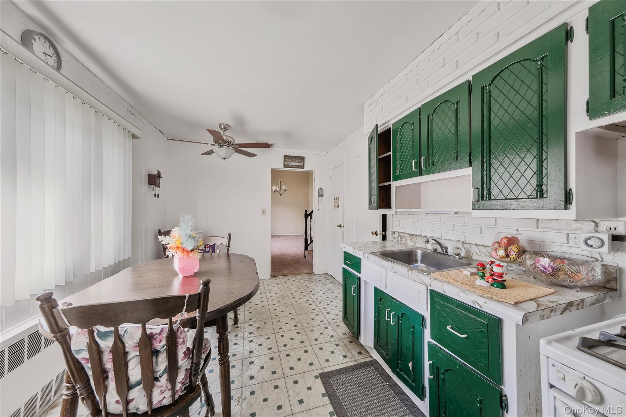 59 Maybrook Road North Babylon, NY 11703 - Photo 7 of 43 a kitchen that has a lot of cabinets a sink and a dining table with chairs